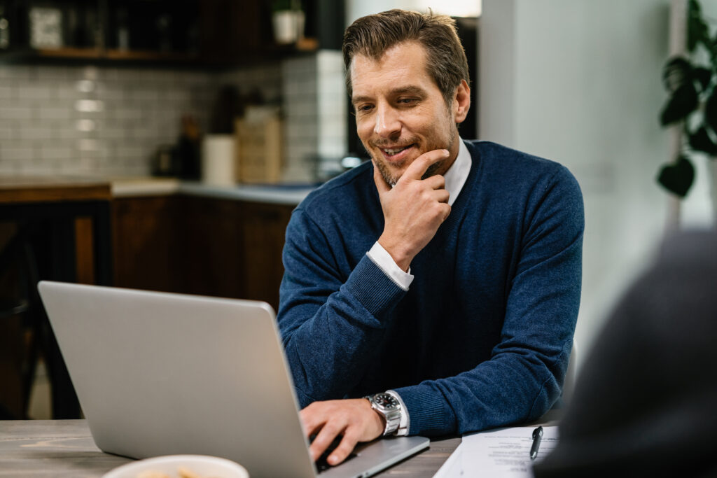 smiling mid adult businessman reading email while working computer